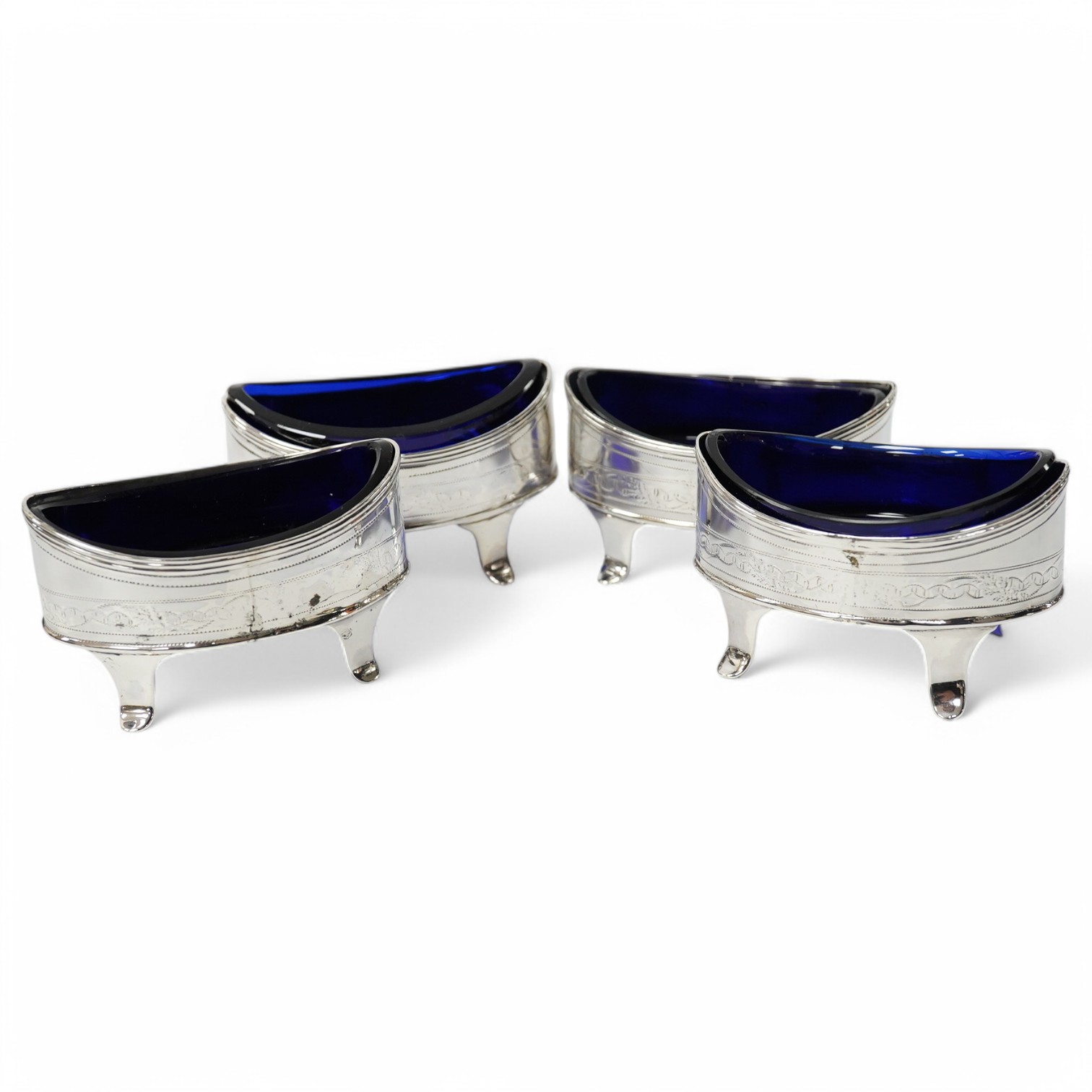 A set of four George III silver oval salts (a.f.) with blue glass liners, London, 1800, 83mm. Condition - poor